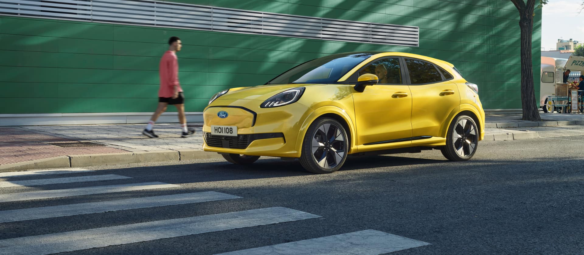 Une Ford Puma Gen-E jaune garée sur le bord de la route.