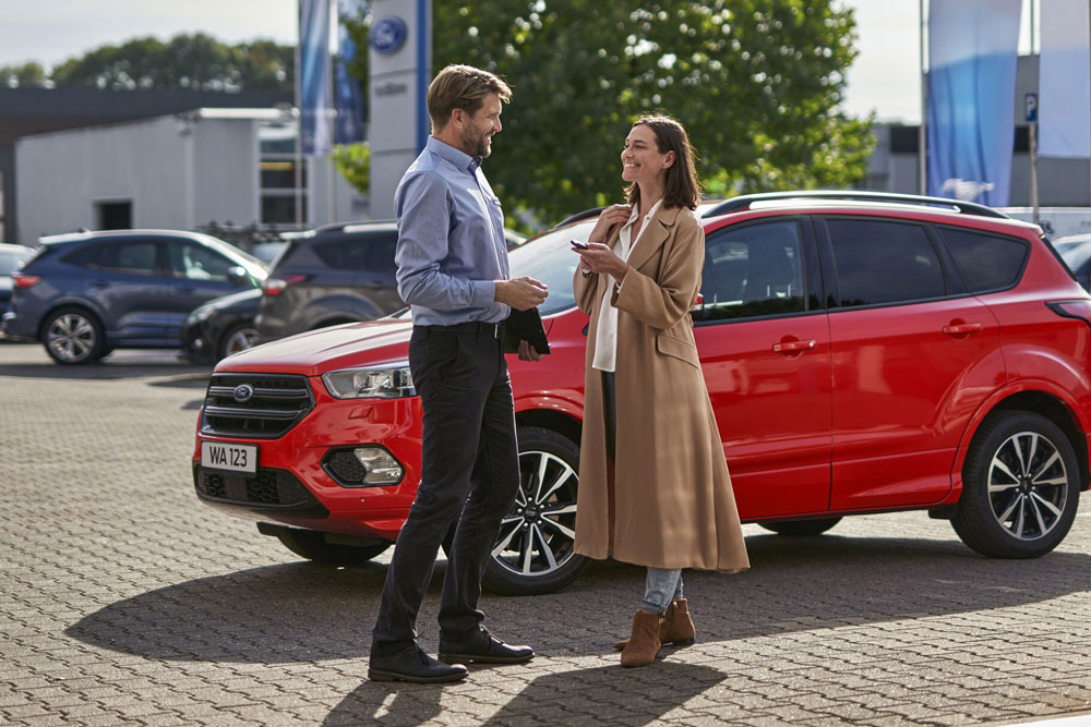 Une femme donnant des clés au conseiller de clientèle Ford Service.