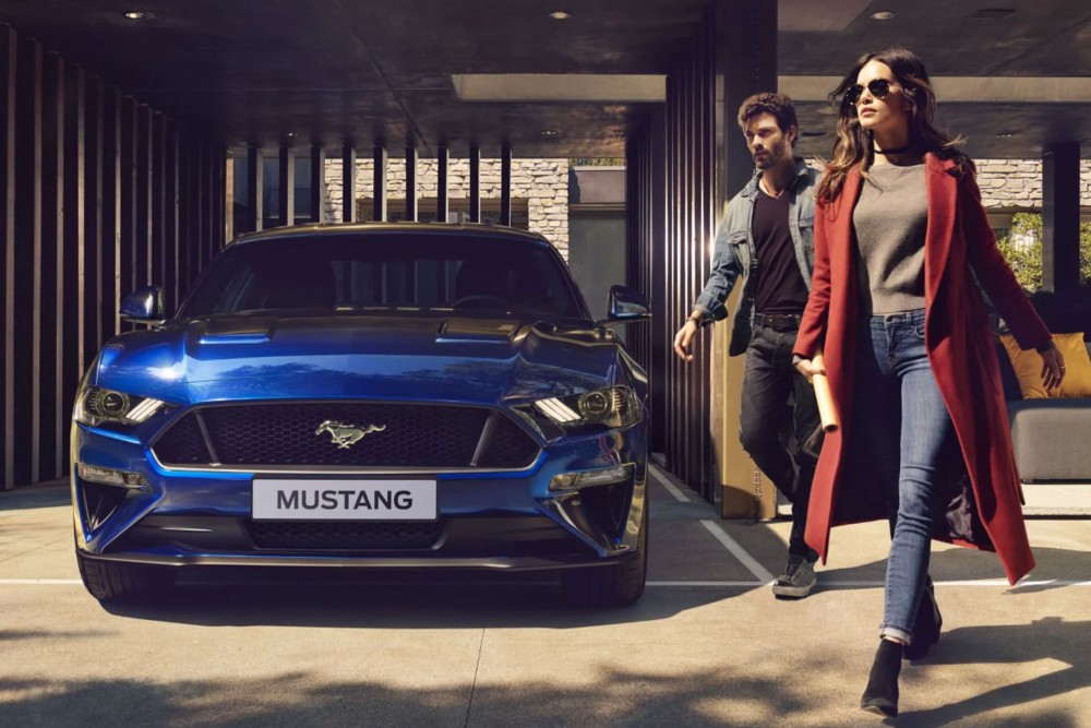 Ford Mustang bleue garée devant la maison