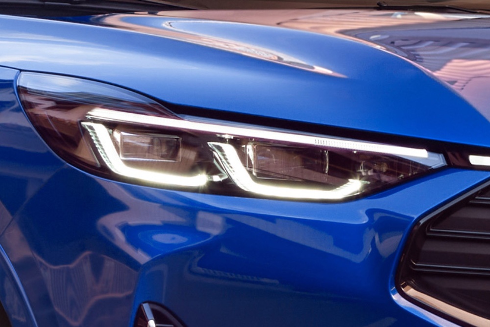 Gros plan du phare avant d’une Ford Mustang Mach-E bleue.