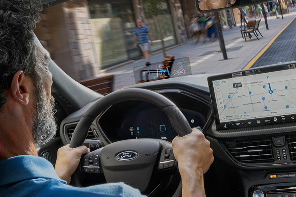 Photo intérieure d’un homme conduisant la Ford Kuga sur une route urbaine.