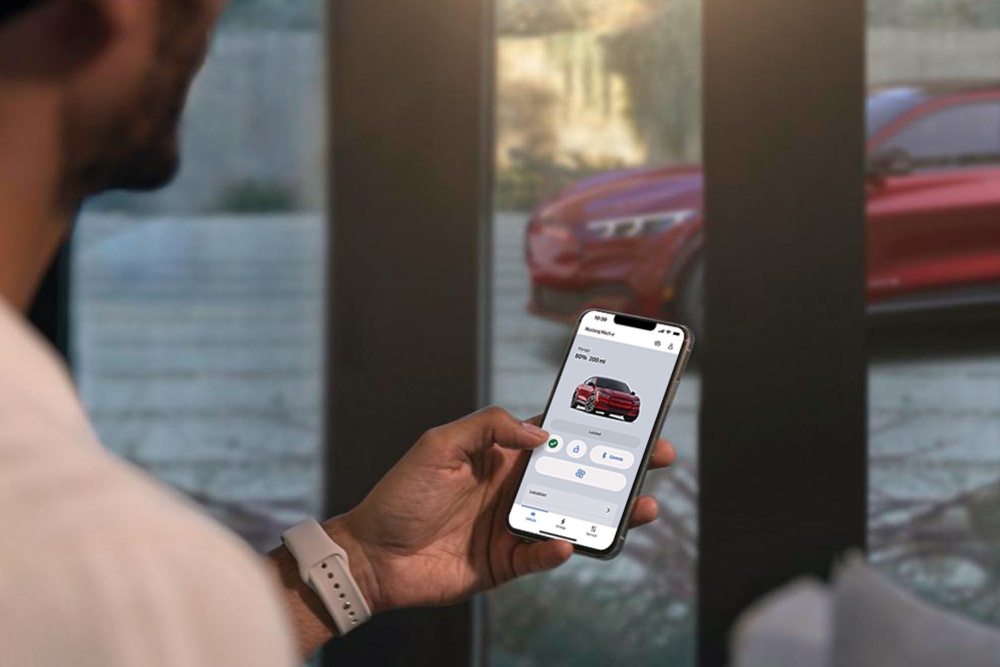 Homme vérifiant les paramètres de sa toute nouvelle Ford Mustang Mach-E à l’aide des fonctions de contrôle à distance du véhicule de l’application FordPass