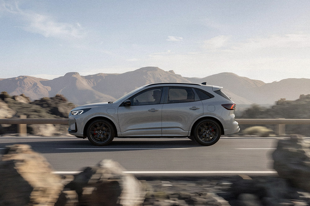Ford Kuga gris roulant sur une route de montagne pittoresque. 