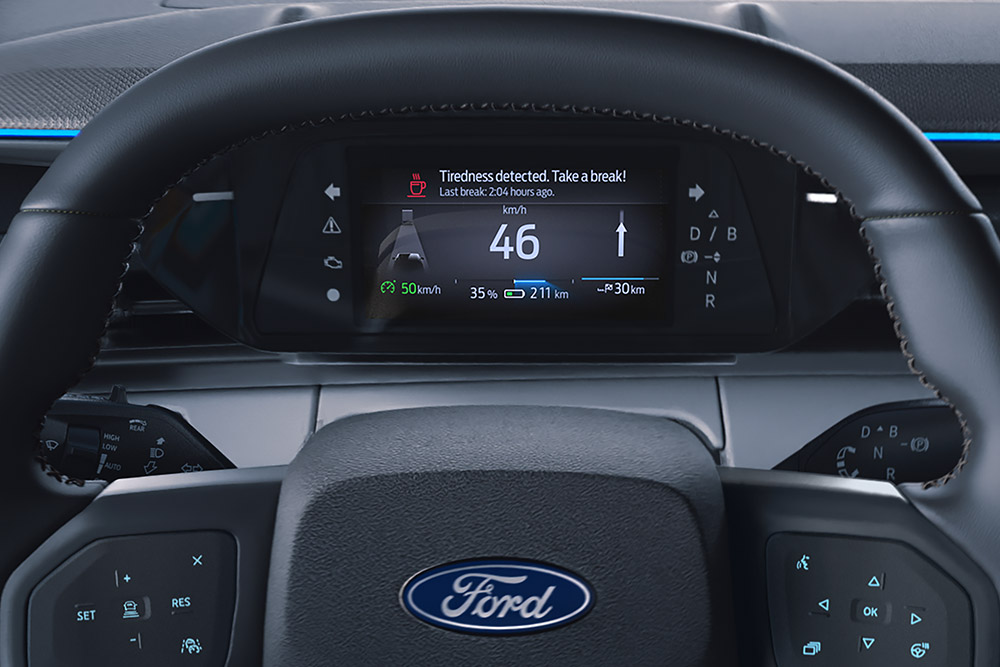 Le tableau de bord numérique derrière le volant du Ford Explorer, affichant la fonction Alerte Conducteur.