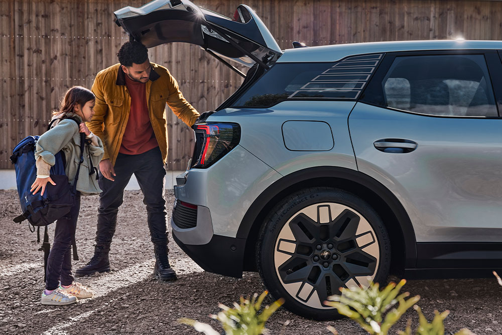 Un père et sa fille chargent le coffre d’un Ford Explorer® argenté.
