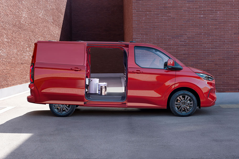 Un livreur décharge des colis d'un Ford Transit Custom rouge.