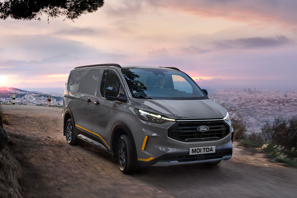 Fourgon Ford Transit Custom Trail gris avec des touches de jaune.