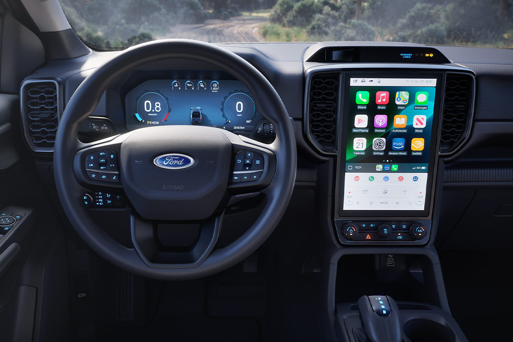 Vue intérieure d’un Ford Ranger Super Cab, centrée sur le volant, le tableau de bord et l’écran d’infodivertissement.