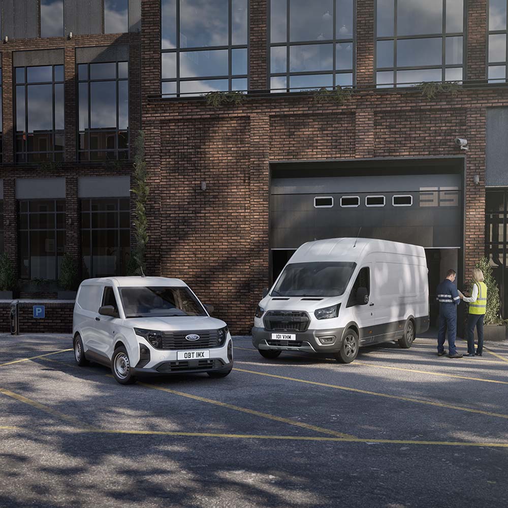 Deux fourgons Ford blancs stationnés devant un bâtiment moderne avec deux personnes discutant à côté des véhicules.