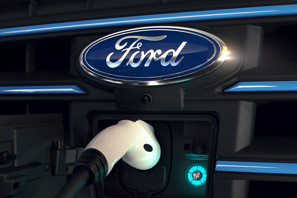 Gros plan d’un câble de charge blanc branché sur la prise de recharge avant d’un véhicule électrique Ford.